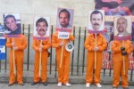 Los activistas se presentaron vestidos con uniformes de color naranja similares a los de presos de cárceles estadounidenses y pancartas con las fotos de los Cinco.