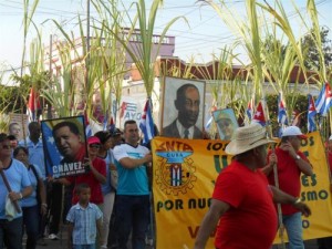 Banderas cubanas gigantes, carteles alegóricos a la celebración y los colores azul, rojo y protagonizan la marcha en Sancti Spíritus.