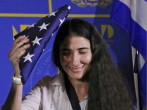 La bloguera Yoani Sánchez recibe una bandera estadounidense de regalo durante un acto organizado en Miami por la mafia anticubana.