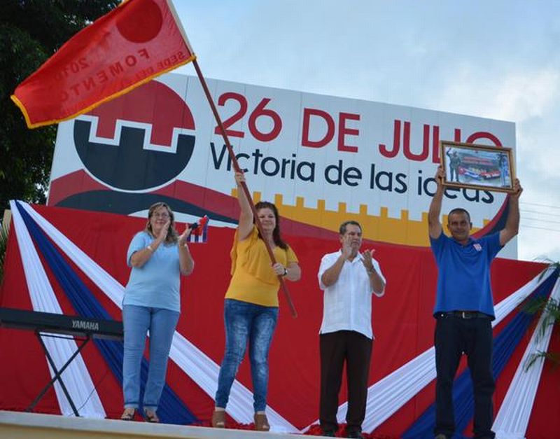 La secretaria del Partido en Fomento exhibe la bandera de municipio ganador del acto provincial por el 26 de julio. (Foto: Oscar Alfonso/ ACN)