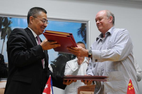 Rodrigo Malmierca y Zhang Xiangchen intercambian los documentos firmados. (Foto: ACN)