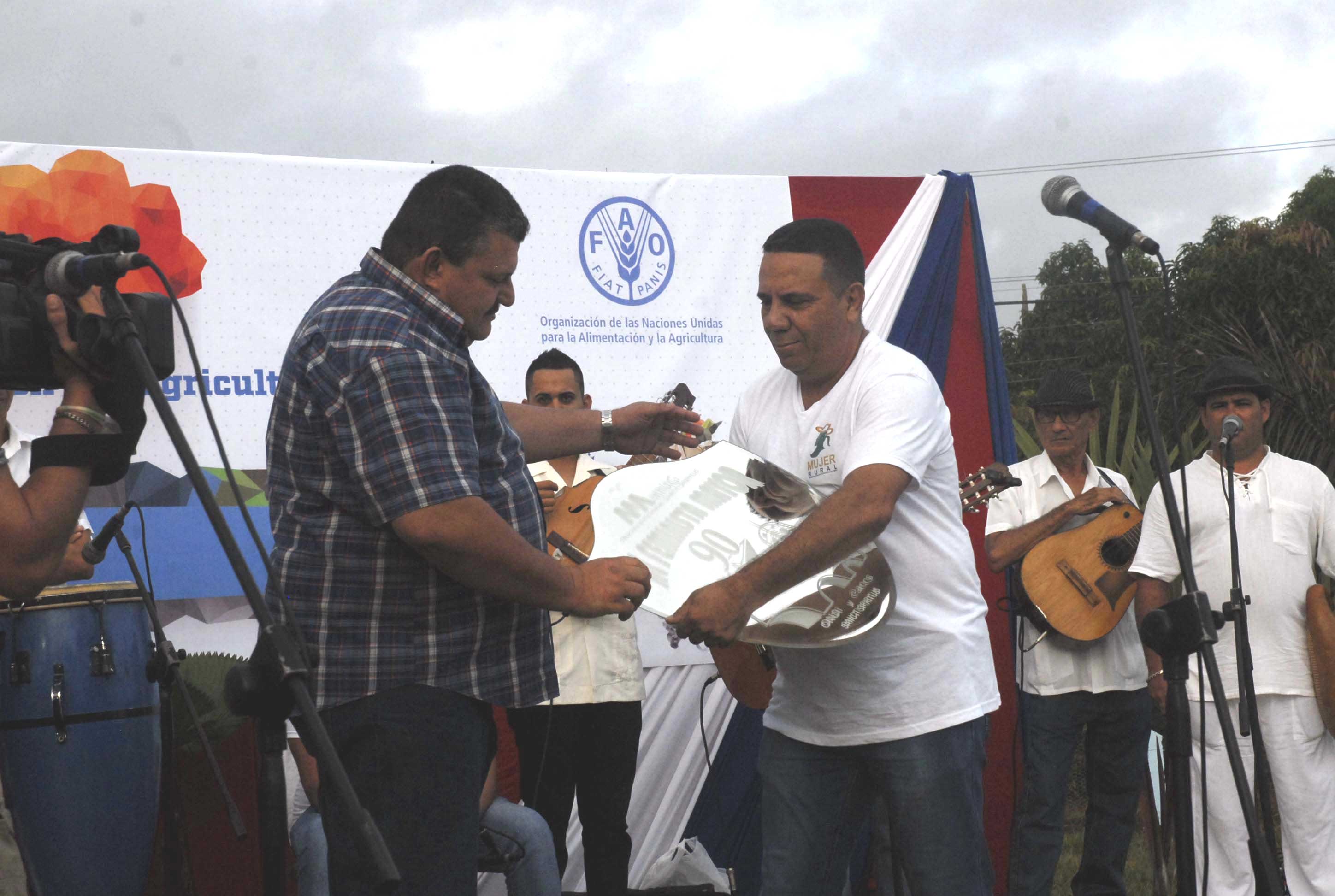 El artista Enrique Neira entrega al presidente de la ANAP una obra de arte en nombre de la Asociación de Comunicadores Sociales. (Foto: Elizabeth Borrego/ Escambray)