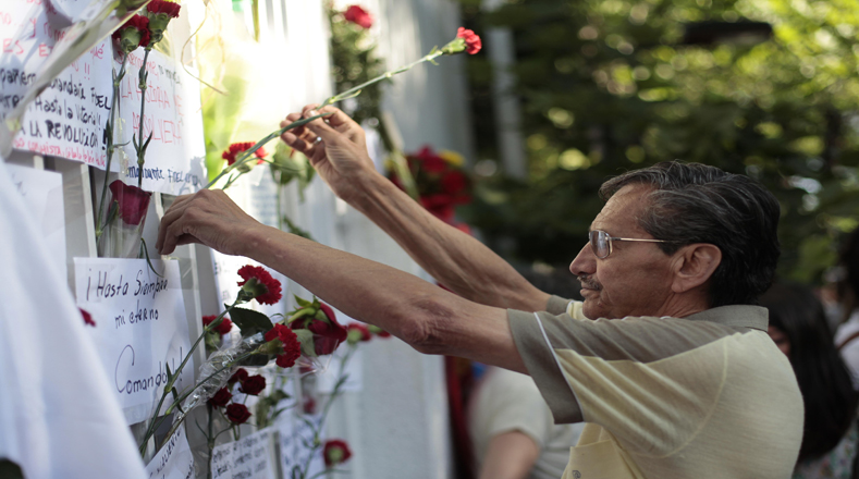 Un hombre deposita flores durante un homenaje frente a la embajada de Cuba, luego del fallecimiento del líder de la Revolución cubana, Fidel Castro, en Santiago, capital de Chile, el 26 de noviembre de 2016. (Foto:Xinhua)