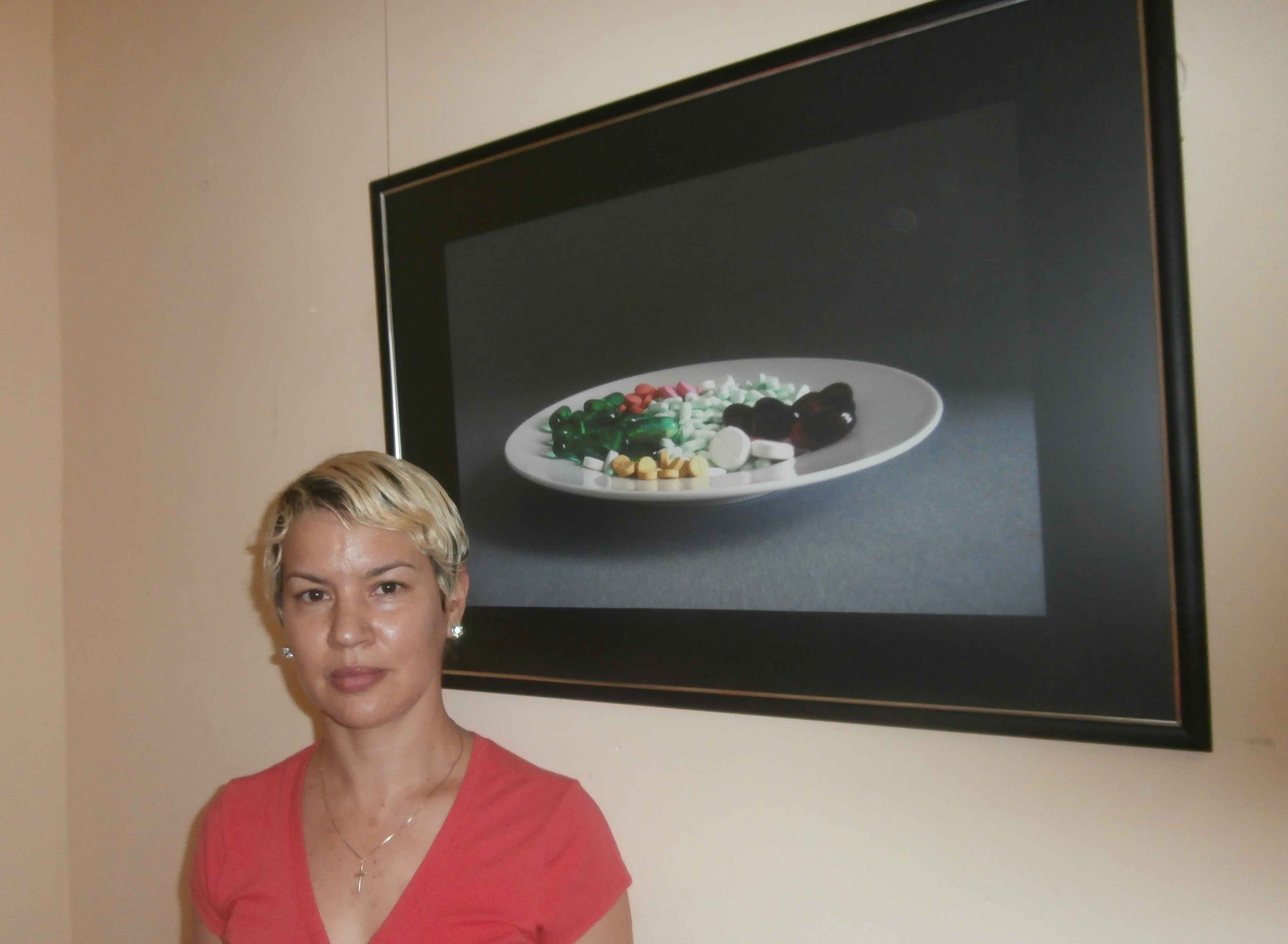 Lisandra López Sotuyo, junto a una de sus instantáneas impresas en lienzo. (Foto: Lisandra Gómez)