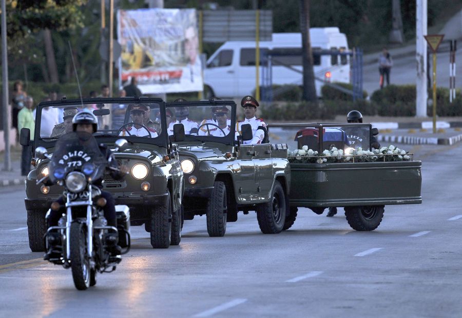 The urn with the ashes of Cuban leader Fidel Castro leaves Revolution Square in Santiago, Cuba on December 4, 2016 on its way to the cemetery. The ashes of late Cuban leader Fidel Castro were taken on Sunday to be laid to rest at a cemetery in the eastern city of Santiago de Cuba. / AFP PHOTO / PEDRO PARDO