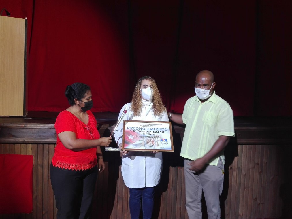 La jefa de la brigada, la doctora Leonela Esther Caña Rivas, recibe el reconocimiento de las autoridades trinitarias.