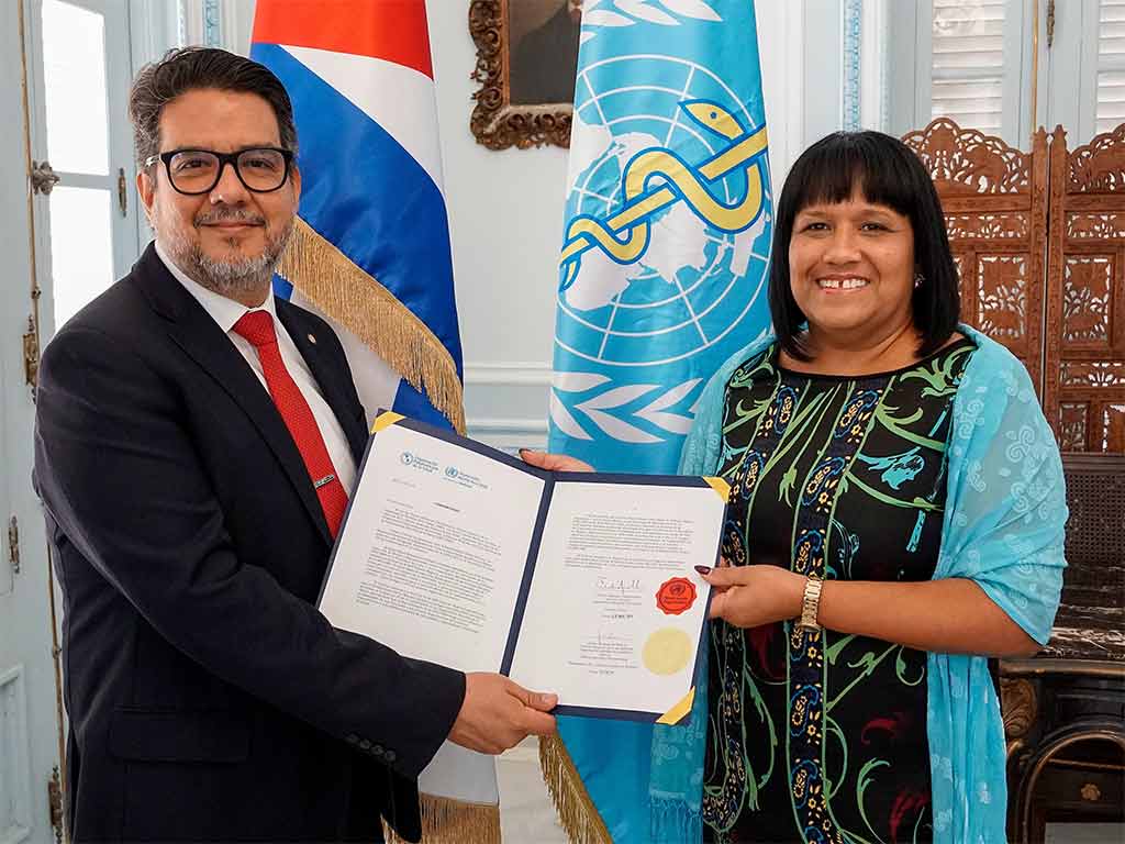 Anayansi Rodríguez recibió de manos de Mario Ernesto Cruz Peñate, nuevo representante de la OPS/OMS en Cuba, los documentos que le acreditan como tal.